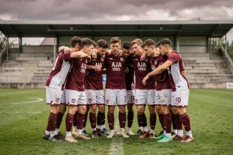 Joueurs de l'AJA 1905 en maillot bordeaux et blanc lors d'un rassemblement sur le terrain du stade d'Auxerre