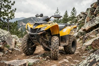 Yamaha Raptor 700 garé sur un sentier de montagne rocheux entouré de pins, idéal pour la randonnée sportive tout-terrain